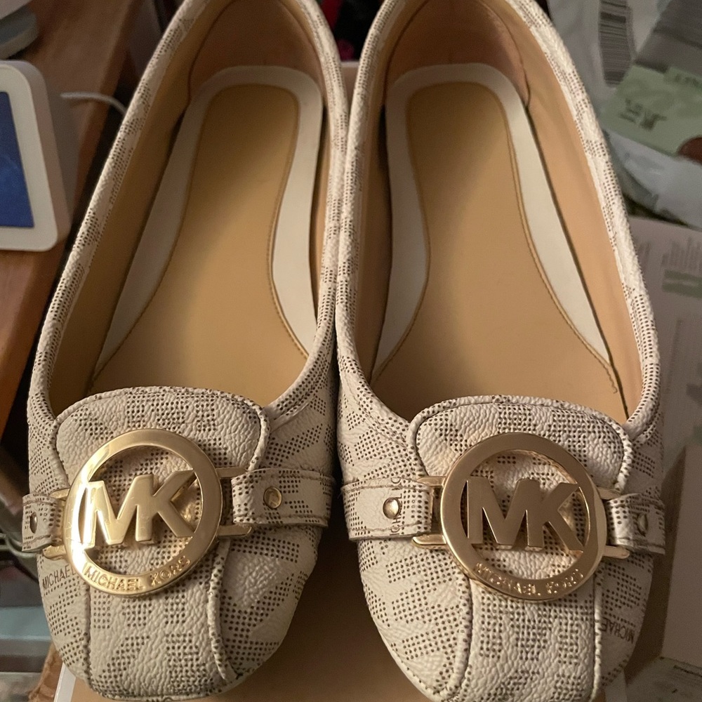 Michael Kors flats with gold hardware.